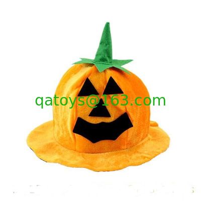 オレンジはカボチャ帽子のハロウィンのプラシ天のおもちゃのかわいいぬいぐるみをからかいます